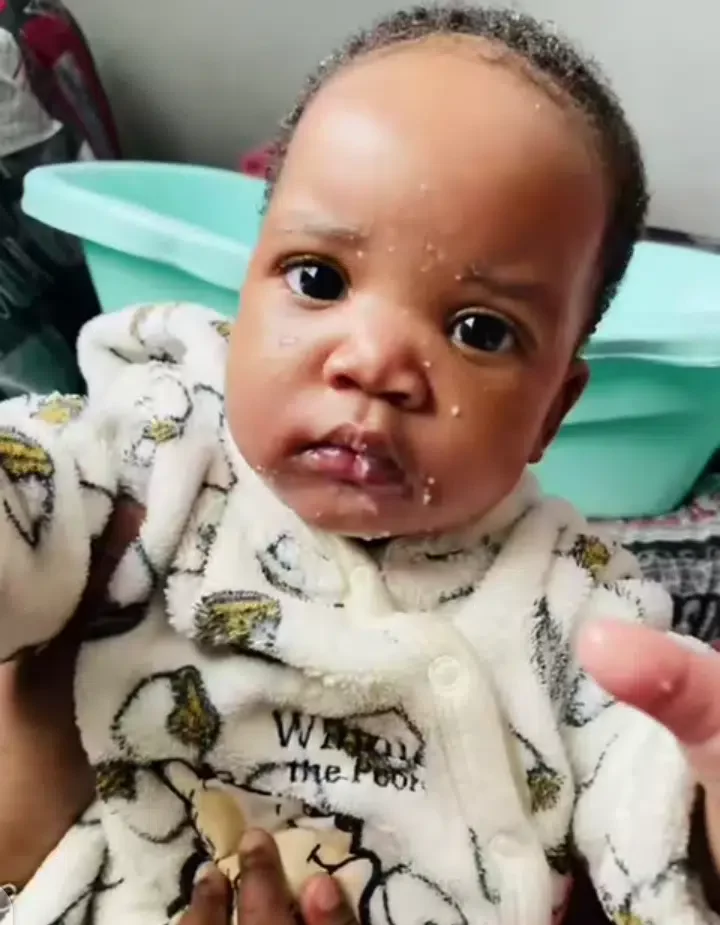 Nigerian lady stirs reactions with unique way of feeding her baby (video)