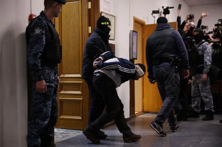 Four men showing signs of severe beating charged over Moscow concert attack