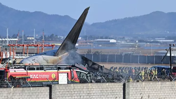 Firefighters and rescue team members work in the aftermath of the crash.<br />Pic: Lee Young-ju/Newsis/AP