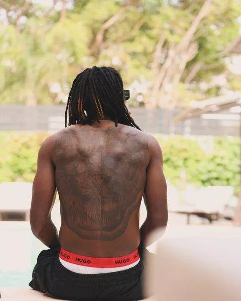 Olisa Ndah showcases his huge tattoo.