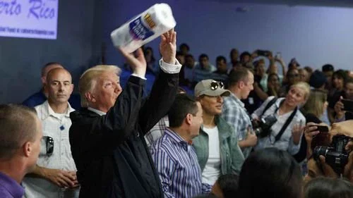 President Donald Trump tosses paper towels into the crowd during his visit to Puerto Rico in the aftermath of Hurricane Maria.