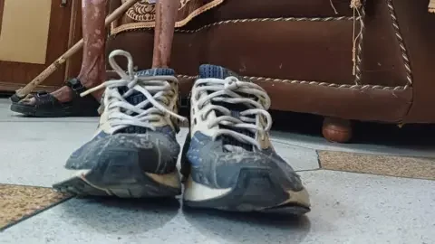 Saurabh Duggal/BBC Pictured Singh's blue and white running shoes covered, worn out from use 