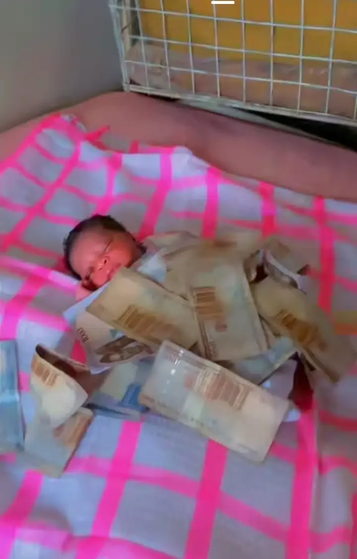 Mixed reactions as young man covers newborn baby with one thousand naira notes