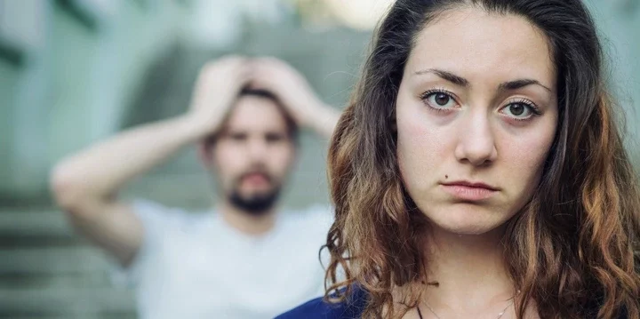 upset woman with distressed man behind her