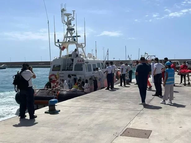 Rescued migrants from a previous incident disembark in Italy