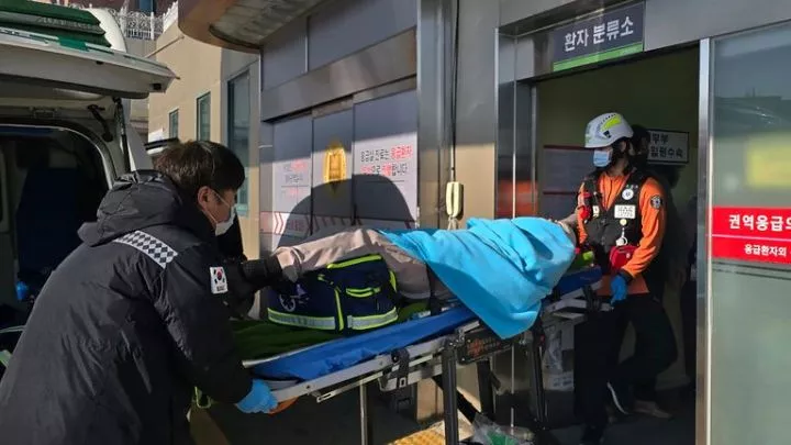 A person rescued from the plane crash is rushed to a hospital in Mokpo.<br />Pic: Cho Geun-young/Yonhap/AP)