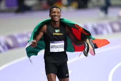 A rising star of Zambia's athletics, Muzala, celebrates with his national flag.