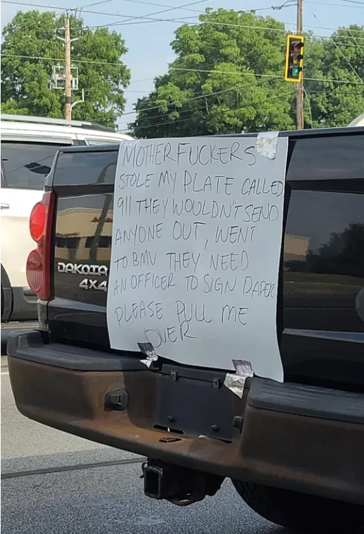 A truck is missing its back license plate, but there&#x27;s a taped sign in its place