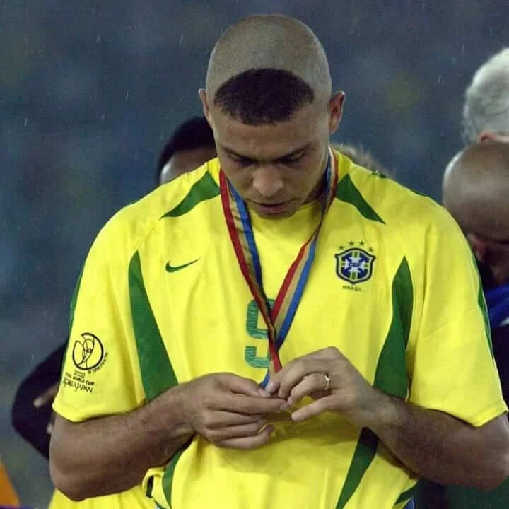 A picture of Ronaldo with heads bowed down rocking the R9 haircut