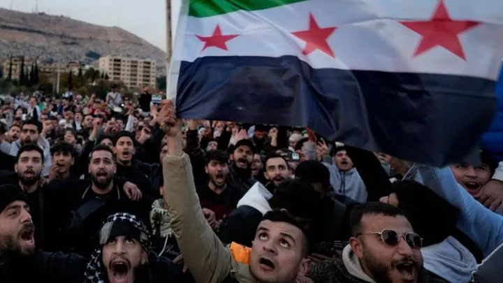 Syrian citizens wave the revolutionary flag and shout slogans, as they celebrate during the second day of the take over of the city by the insurgents in Damascus, Syria, Monday, Dec. 9, 2024. (AP Photo/Hussein Malla)