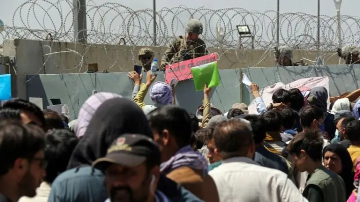 Hundreds of people gather near an evacuation control checkpoint outside the airport at Hamid Karzai International Airport, in Kabul. Pic: AP