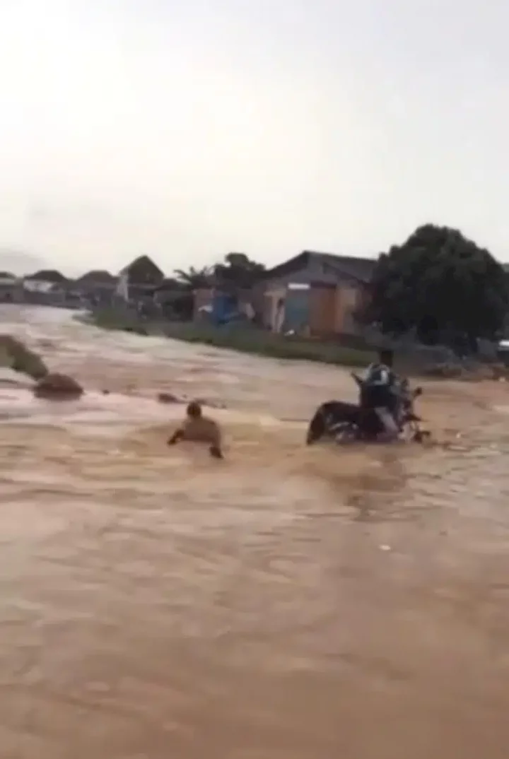 Onlookers stare helplessly as flood washes away bike rider (Video)