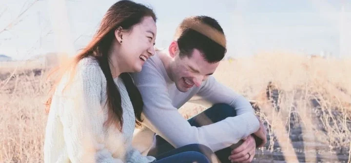 Couple laughing in a field