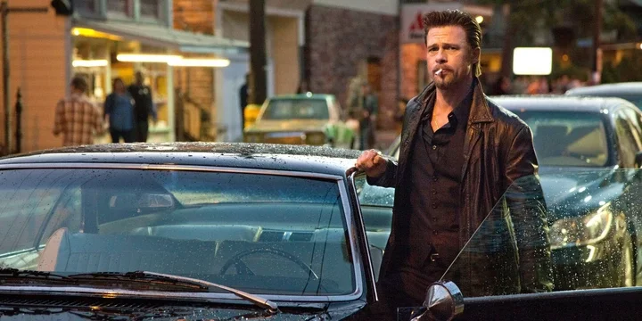 Brad Pitt as Jackie Cogan stepping out of a car and looking intently in 'Killing Them Softly'