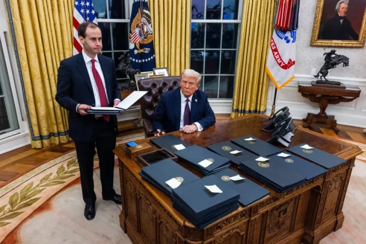 President Trump signing executive orders in the Oval Office.