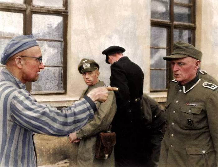 Russian Inmate Points An Identifying And Accusing Finger At A Nazi Guard Who Was Especially Cruel Towards The Prisoners In Buchenwald Camp. Colorized