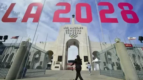 Getty Images The entrance of Los Angeles Memorial Coliseum is reflected on a window that has 'LA 2028