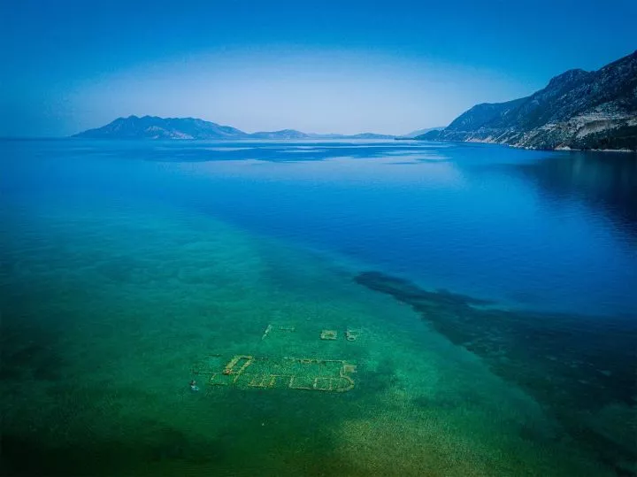 A view of blue water with ruins beneath it