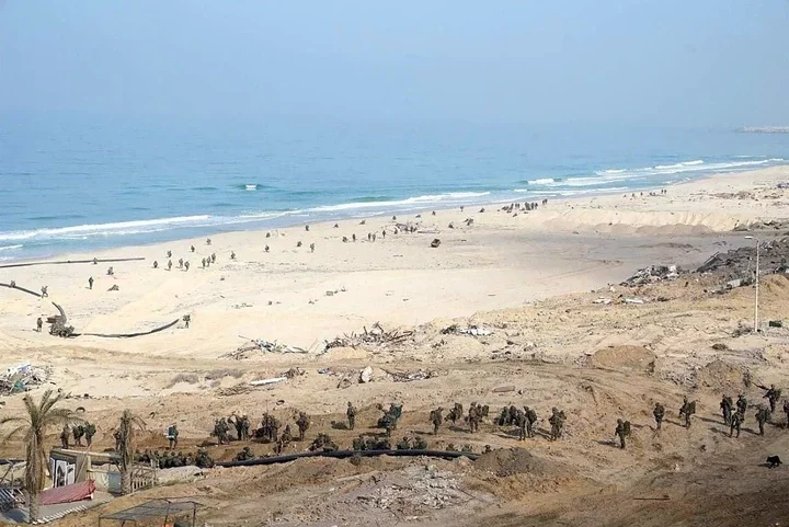 Israeli soldiers appear to be setting up pumps and pipes near the sea