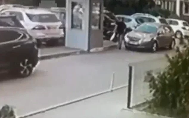 The assassin, wearing a black t-shirt and shorts, was seen on CCTV footage springing out from behind a car and blasting the 50-year-old colonel at point-blank range as he crossed a road