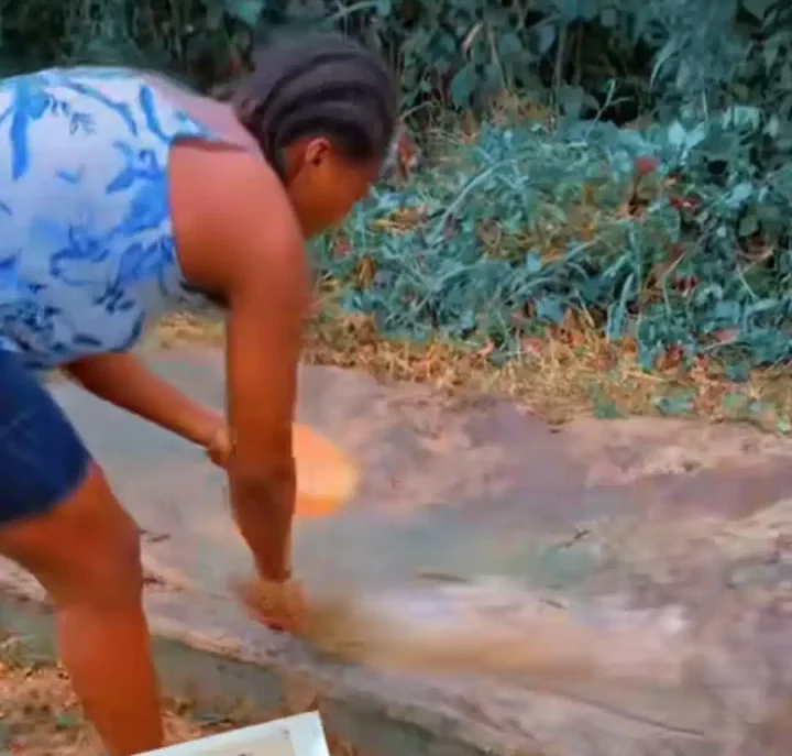 'RIP my gold' - Lady storms her late mother's grave with a broom to sweep and wash off dirt, video stuns many Nigerians