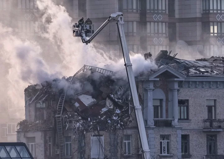 Firefighters work at a site of a building damaged during a Russian drone strike on New Year's Day in Kyiv