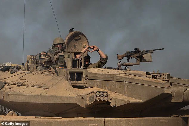 An IDF soldier makes a heart with his hands while inside a tank on November 17, 2023 in southern Israel