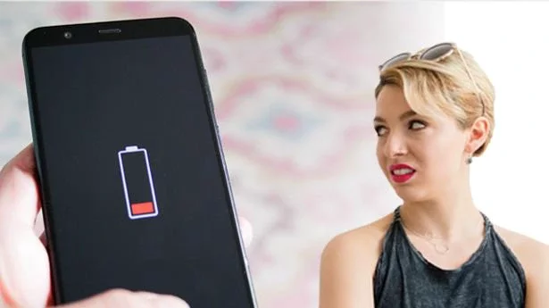 An annoyed woman and a low battery sign on a mobile phone