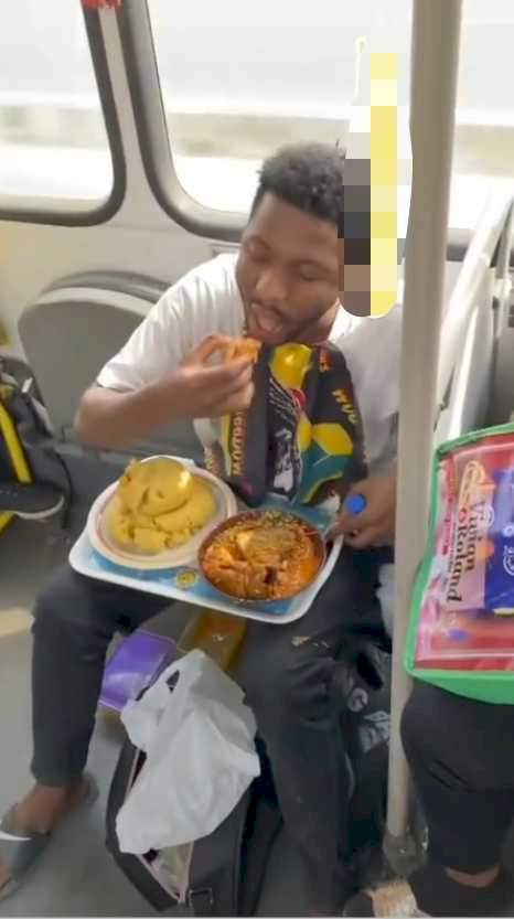 Man spotted aggressively dealing with a huge bowl of eba and soup inside a BRT bus in Lagos (Video)