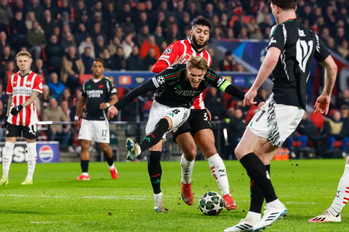 Martin Odegaard of Arsenal FC shoots at the goal during a soccer match.