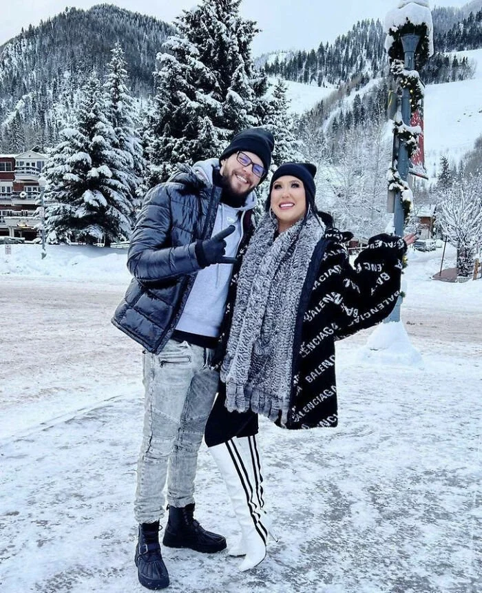 The Snowy White Landscape Paired With This Lady's Striped Boots Makes It Appear Like She Is A Floating Torso With No Legs