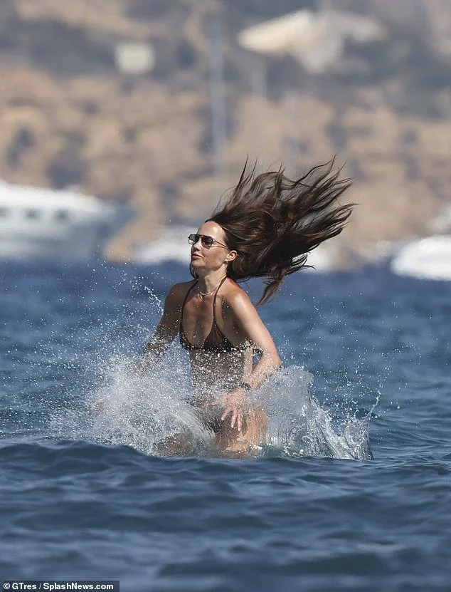 She shielded her eyes behind a pair of quirky sunglasses as she cooled off by jumping into the water off the back of the boat.