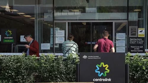 People wait outside a Services Australia outlet