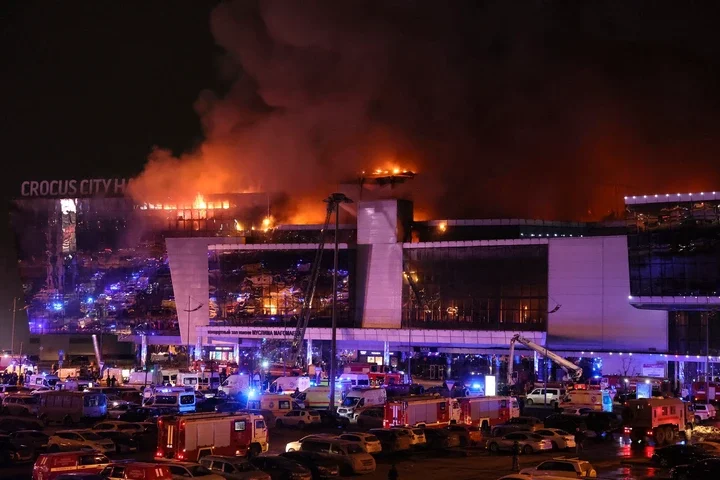 <p>Emergency services vehicles are seen outside the burning Crocus City Hall concert hall following the shooting incident in Krasnogorsk, outside Moscow, on March 22, 2024</p>