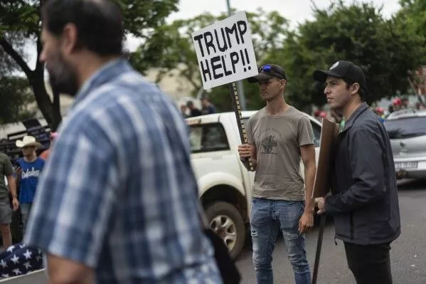 White South Africans demonstrate in support of U.S. President Donald Trump in front of the U.S. embassy in Pretoria, South Africa, Saturday, Feb. 15, 2025. (AP Photo/Jerome Delay)