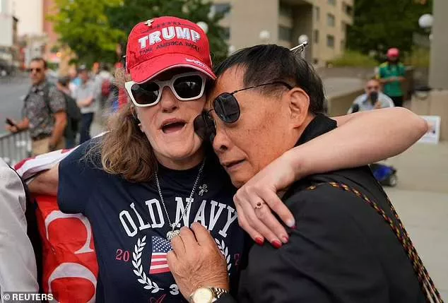 Two Trump supporters hold each other in anguish as word of the verdict filters through to the crowd outside