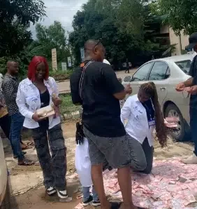 Big men make money rain on lady as she signs out of school, video goes viral