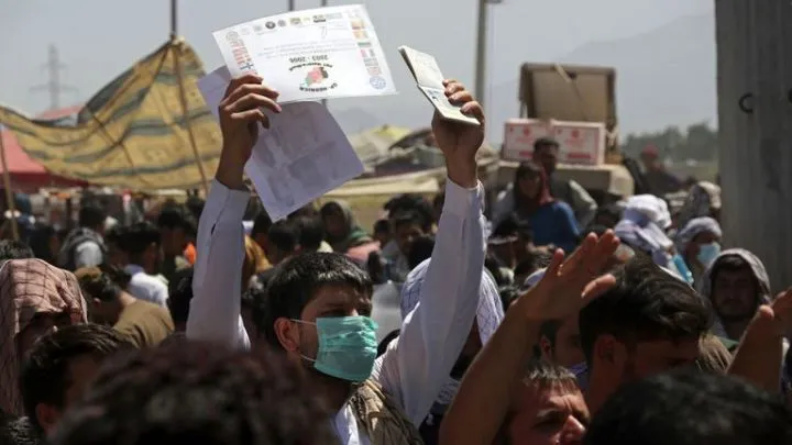 Hundreds of people gather some holding documents, near an evacuation control checkpoint on the perimeter of the Hamid Karzai International Airport, in Kabul. Pic: AP