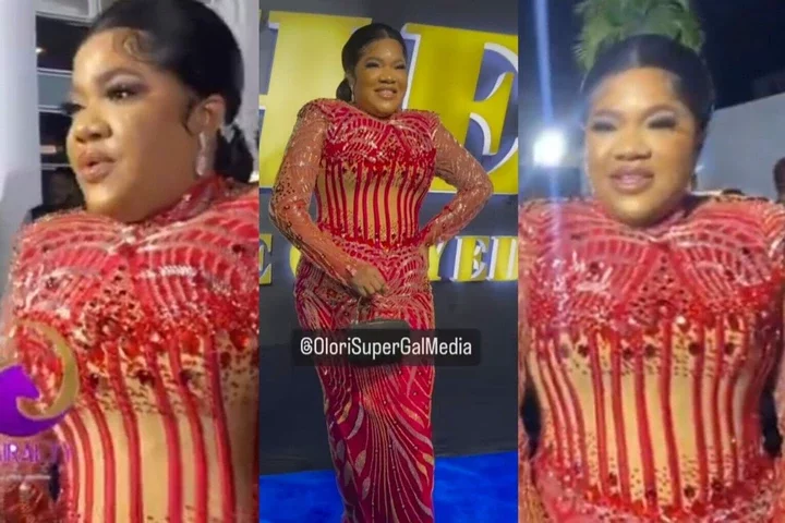 "Her tailor must be arrested" Netizens mock Toyin Abraham as she struggles to breathe over a tight dress at an event (Video)