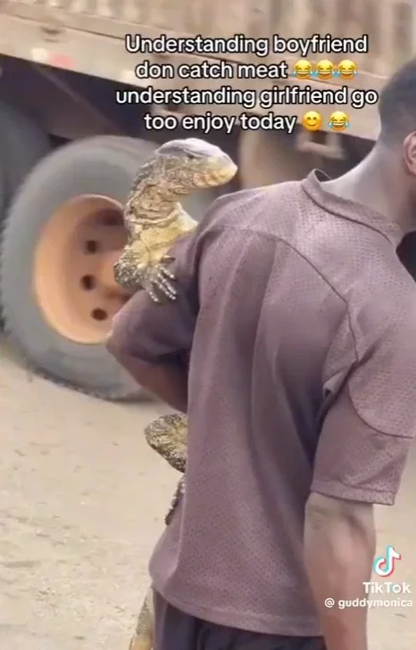 Man spotted carrying a monitoring lizard like a baby in the streets of Lagos (video)