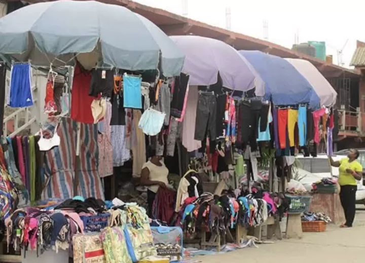 Lady selling second hand clothes in market causes buzz as she sings, shakes waist to attract customer (Video)