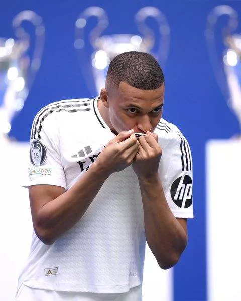 Kylian Mbappe kisses the Real Madrid badge during his presentation.