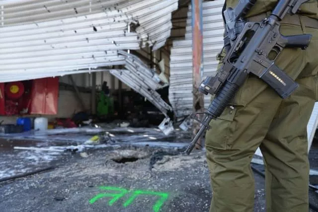  Israeli security forces at the site where a missile fired from Lebanon hit a garage in the northern Israeli city of Kiryat Shmona, October 4, 2024. (photo credit: AYAL MARGOLIN/FLASH90)