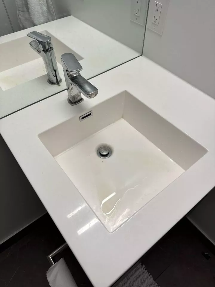 Modern bathroom with a square-shaped sink with a flat bottom. Water sits at the bottom without draining