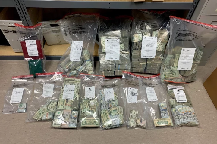 The photos show the huge stash of cash, consisting of hundred, fifty and twenty dollar bills divided up into a dozen clear baggies 