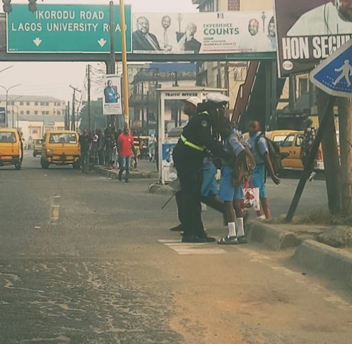 Policewoman praised for making it her duty to properly dress students while working on the streets of Lagos (photos)