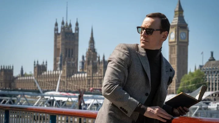 Michael Fassbender leans against a wall and looks the other way in Black Bag.