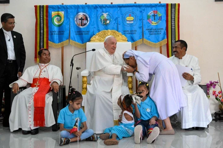 Pope Francis (C) blesses a nun during a visit for children with disabilities at the Irmas Alma school in Dili.