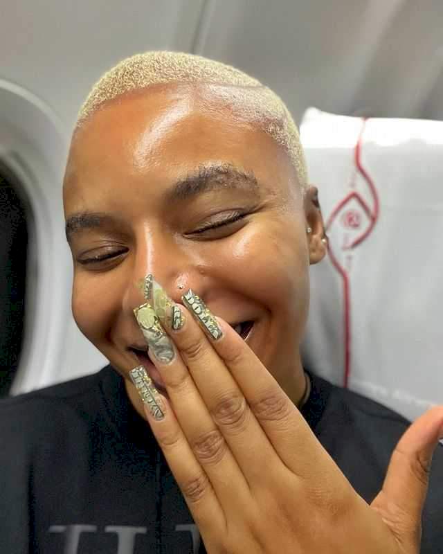 Reactions as Nancy Isime decorates her nails with dollar bills (Video)