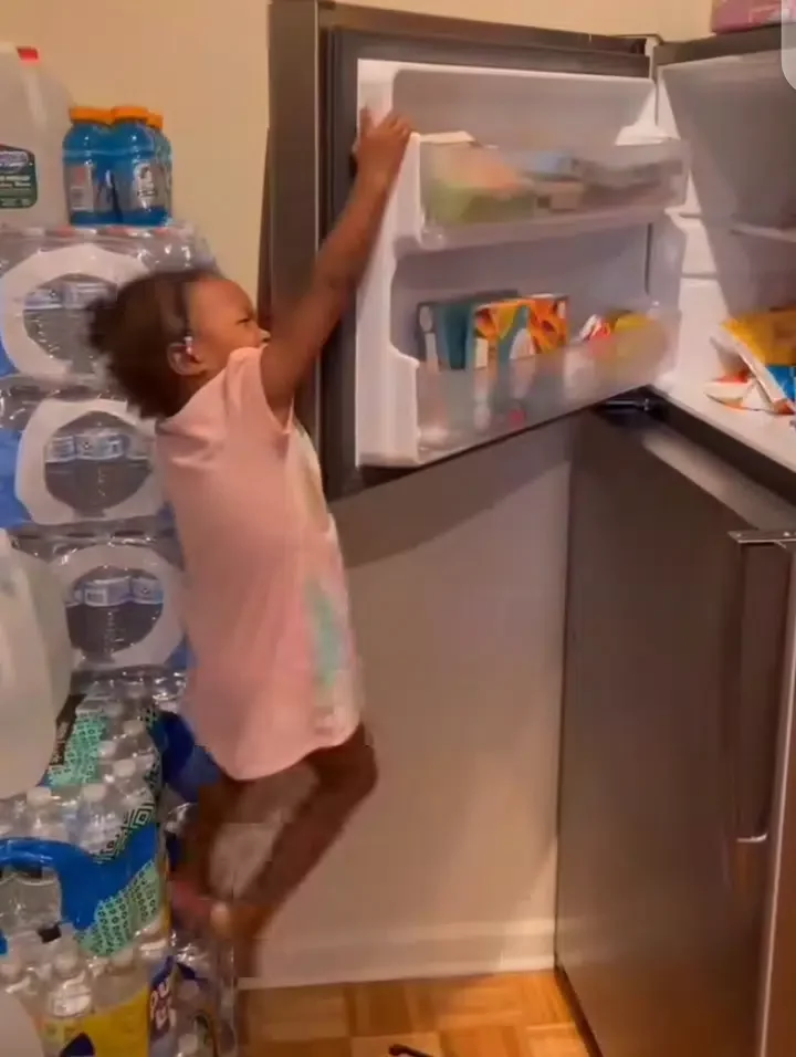 Scary moment a little girl climbed fridge to steal snacks and got stuck (Video)